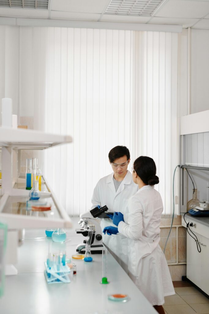 pexels-photo-4031419-4031419 Two scientists in lab coats working in a sophisticated laboratory setting.